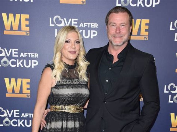 Tori Spelling’s husband tweets a photo with her giant tatas in the background